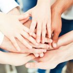 Many people putting their hands together