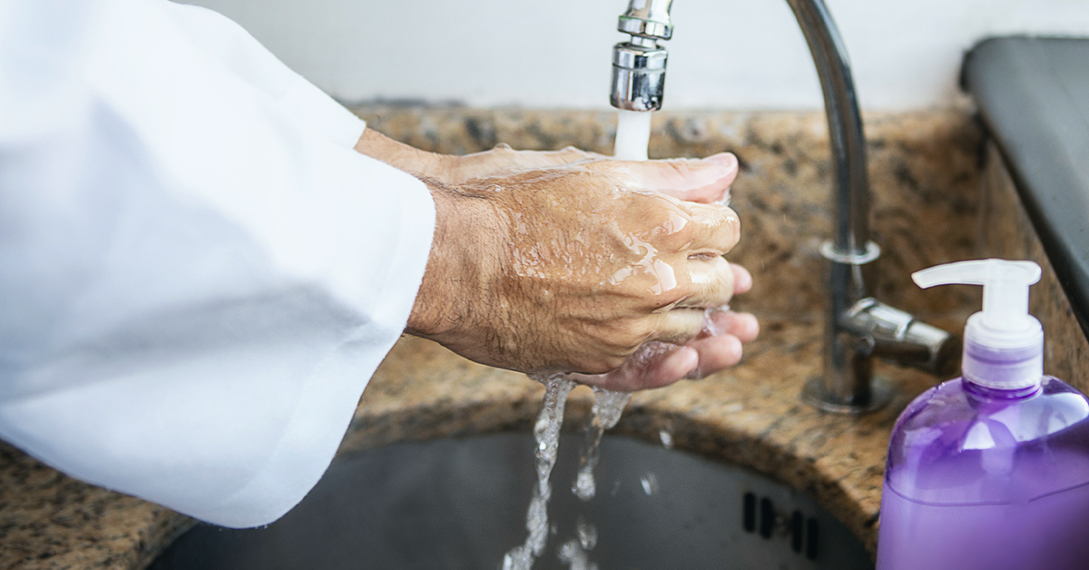 Dentist washing hands with soap and water.