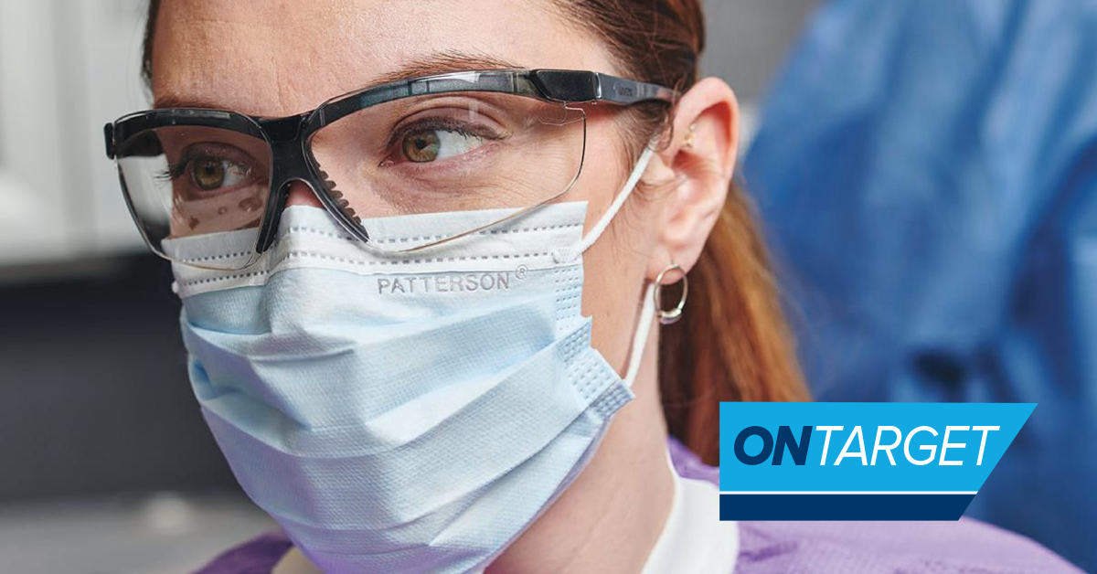 Dental hygienist with face mask and protective eyewear.