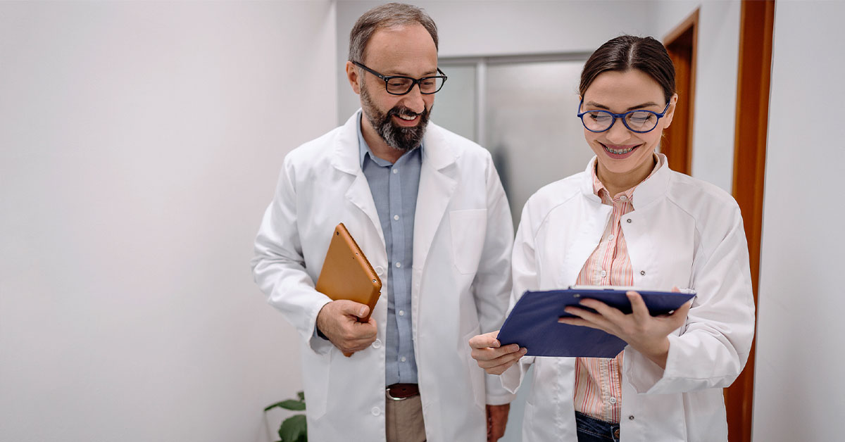 Stock photo of two dentists conversing in a hallway of a dental office.